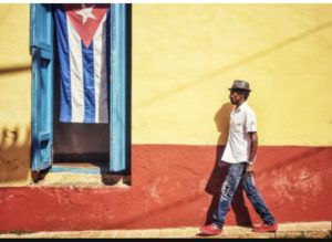 Cuba_Flag_and_Colored_Wall_with_Cuban_Man